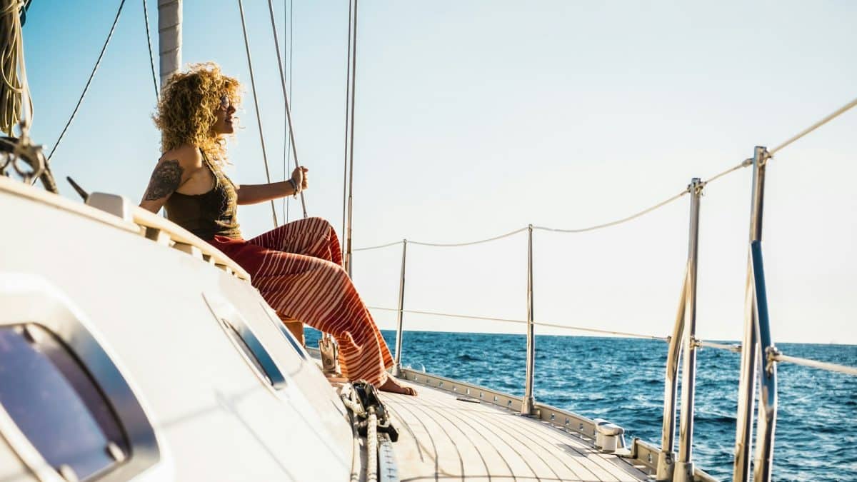 Young beautiful girl lay down and relax on a sail boat