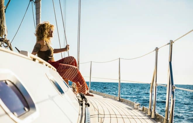 Young beautiful girl lay down and relax on a sail boat